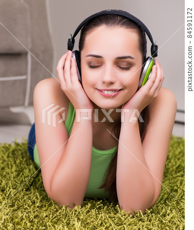 Young woman listening to music at home 84591172