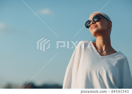 Millenial young woman blonde short hair outdoor smiling portrait. 84591543