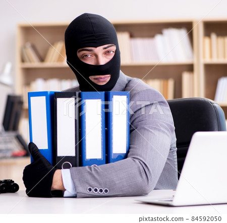 Criminal businessman wearing balaclava in office Criminal businessman wearing balaclava in office 84592050