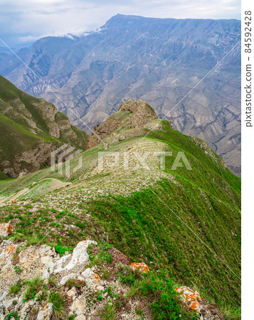 Perspective of rocky ledge. Edge of the cliff, a dangerous gorge. Vertical view. Perspective of rocky ledge. Edge of the cliff, a dangerous gorge. Vertical view. 84592428