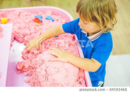 Boy playing with kinetic sand in preschool. The development of fine motor concept. Creativity Game concept Boy playing with kinetic sand in preschool. The development of fine motor concept. Creativity Game concept 84593468
