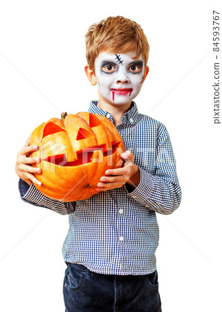 blond boy in makeup with big orange carved pumpkin 84593767