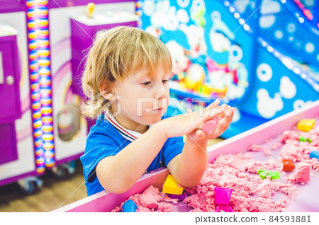 Boy playing with kinetic sand in preschool. The development of fine motor concept. Creativity Game concept Boy playing with kinetic sand in preschool. The development of fine motor concept. Creativity Game concept 84593881