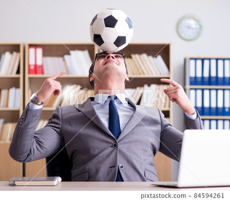 Businessman with football ball in office 84594261