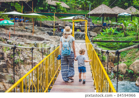 Mother and son are going on a suspension bridge. Traveling with children concept 84594966
