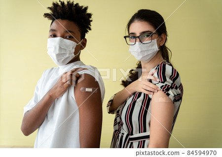 Diverse group of people showing COVID-19 vaccine bandage merrily Diverse group of people showing COVID-19 vaccine bandage merrily 84594970