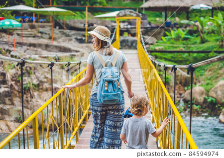 Mother and son are going on a suspension bridge. Traveling with children concept Mother and son are going on a suspension bridge. Traveling with children concept 84594974