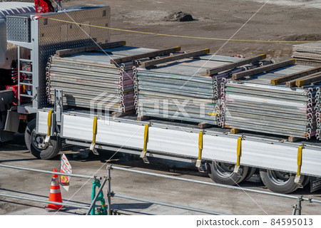 Truck delivering scaffolding to a construction site Truck delivering scaffolding to a construction site 84595013