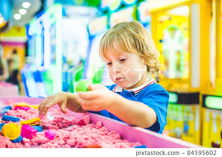 Boy playing with kinetic sand in preschool. The development of fine motor concept. Creativity Game concept Boy playing with kinetic sand in preschool. The development of fine motor concept. Creativity Game concept 84595602