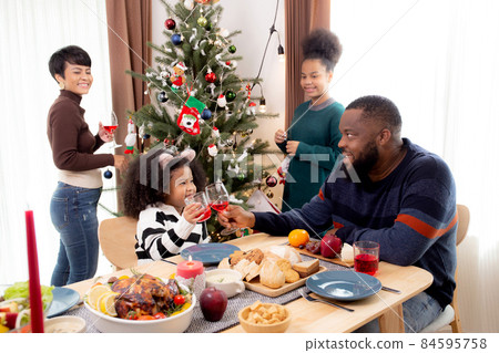 Happy African family eating food in dinner on festive thanksgiving eve day together at home.