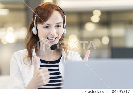 Foreign woman wearing a headset to like a computer Foreign woman wearing a headset to like a computer 84595817