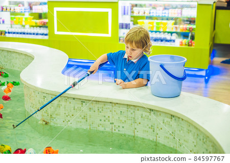 Cute boy in the playroom fishing. The development of fine motor concept. Creativity Game concept Cute boy in the playroom fishing. The development of fine motor concept. Creativity Game concept 84597767
