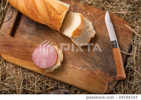 French folding knife and sausage sandwich. A folding kitchen knife and a homemade sandwich. 84598103
