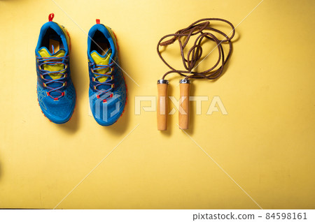 Sports sneakers and skipping rope. Cardio on a rope. Rope exercises. Top view. Sports sneakers and skipping rope. Cardio on a rope. Rope exercises. Top view. 84598161
