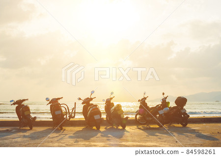 Silhouette scooter at seaside with sunset background 84598261