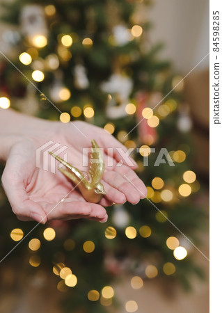hand holding toy and decorating Christmas tree. Holiday, Christmas and New Year celebration concept hand holding toy and decorating Christmas tree. Holiday, Christmas and New Year celebration concept 84598285