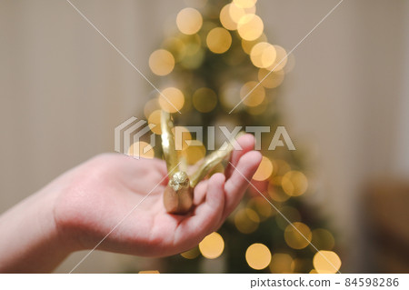 hand holding toy and decorating Christmas tree. Holiday, Christmas and New Year celebration concept hand holding toy and decorating Christmas tree. Holiday, Christmas and New Year celebration concept 84598286