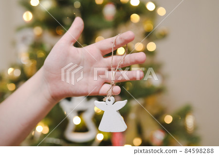 hand holding toy and decorating Christmas tree. Holiday, Christmas and New Year celebration concept hand holding toy and decorating Christmas tree. Holiday, Christmas and New Year celebration concept 84598288