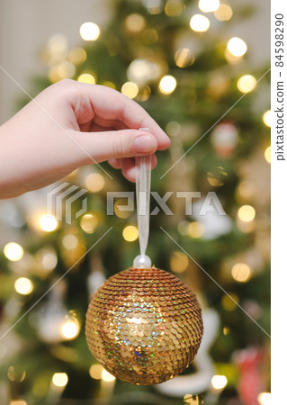 hand holding toy and decorating Christmas tree. Holiday, Christmas and New Year celebration concept hand holding toy and decorating Christmas tree. Holiday, Christmas and New Year celebration concept 84598290