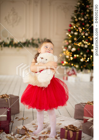 A little girl is enjoying her new teddy bear given by Santa Claus for Christmas A little girl is enjoying her new teddy bear given by Santa Claus for Christmas 84600290