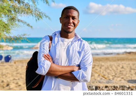 Outdoor portrait of smiling confident man with folded hands, sea nature background. 84601331