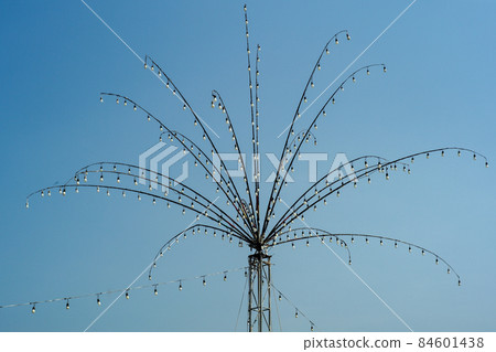 Many bulbs decorated on the steel branches in the shape of flower for local festival in Thailand isolated on blue sky background Many bulbs decorated on the steel branches in the shape of flower for local festival in Thailand isolated on blue sky background 84601438