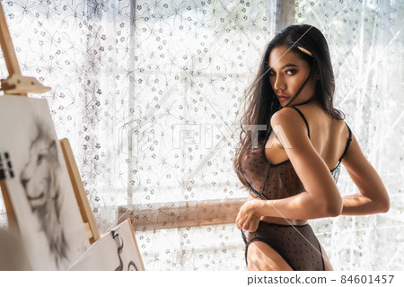 Sexy Asian woman with paintbrush in art gallery 84601457