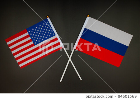 USA flag and Russia flag crossed with each other on the black background. USA vs Russia. Meeting between the presidents of the United States and Russia. Isolated. Top view USA flag and Russia flag crossed with each other on the black background. USA vs Russia. Meeting between the presidents of the United States and Russia. Isolated. Top view 84601569