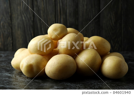 Tasty young potato on black smokey table Tasty young potato on black smokey table 84601940