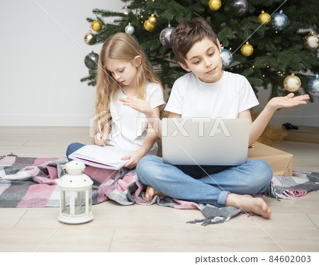 Children play near the Christmas tree. 84602003