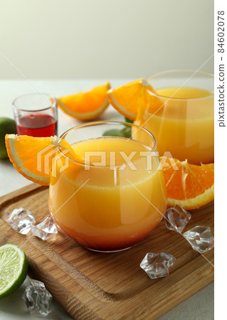 Board with Tequila Sunrise cocktails on white textured table Board with Tequila Sunrise cocktails on white textured table 84602078