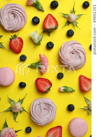 Concept of tasty macaroons and marshmallows on yellow background Concept of tasty macaroons and marshmallows on yellow background 84602101