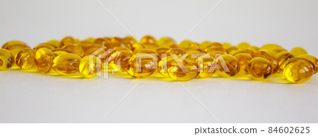 Yellow vitamins tablets, fish oil, Omega Vitamin E. Pills on a white background. Web banner with a copy space. 84602625