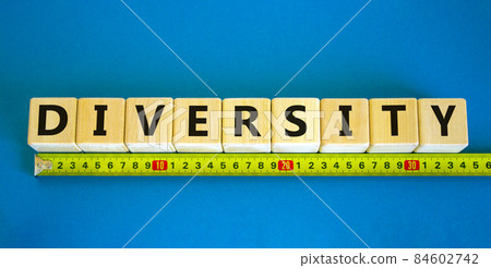 Diversity and better inclusion symbol. The concept word Diversity on wooden cubes. Yellow ruler. Beautiful blue table, blue background. Business, inclusion and diversity concept, copy space. Diversity and better inclusion symbol. The concept word Diversity on wooden cubes. Yellow ruler. Beautiful blue table, blue background. Business, inclusion and diversity concept, copy space. 84602742
