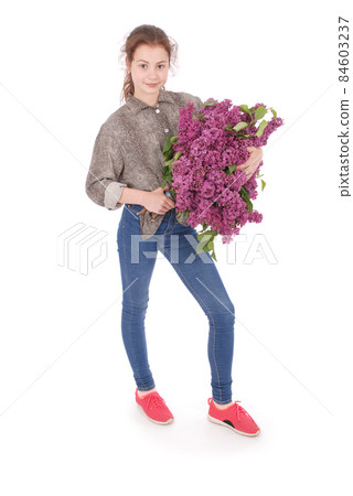 Girl teenager standing with lilac in hands 84603237