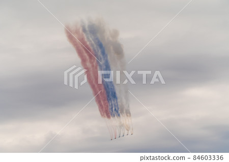Russia. July 25, 2021. SU-25 combat aircraft during the Navy parade fly over Kronstadt and demonstrate the flag of the Russian Federation with smoke bombs. 84603336