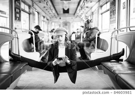 Very flexible woman wearing mask reading book in the subway car sitting in the gymnastic split. Concept of healthy lifestyle and education Very flexible woman wearing mask reading book in the subway car sitting in the gymnastic split. Concept of healthy lifestyle and education 84603981