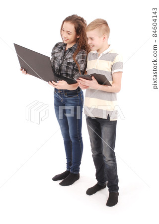 Two kids playing and surfing the web on digital tablet and laptop. Two kids playing and surfing the web on digital tablet and laptop. 84604143