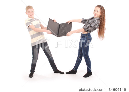 Boy and girl fighting over a laptop Boy and girl fighting over a laptop 84604146
