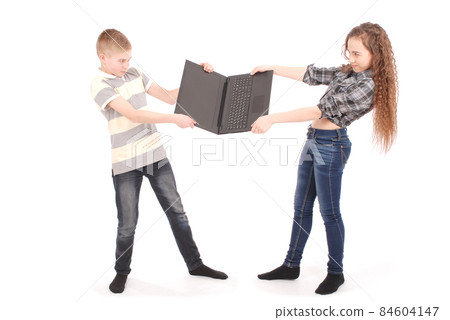 Boy and girl fighting over a laptop Boy and girl fighting over a laptop 84604147