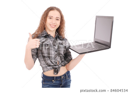 Young girl standing and using a laptop Young girl standing and using a laptop 84604534