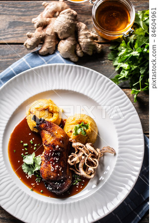 Slow roasted chicken leg on honey and ginger, mashed potatoes with onion and coriander - Top of view Slow roasted chicken leg on honey and ginger, mashed potatoes with onion and coriander - Top of view 84604961