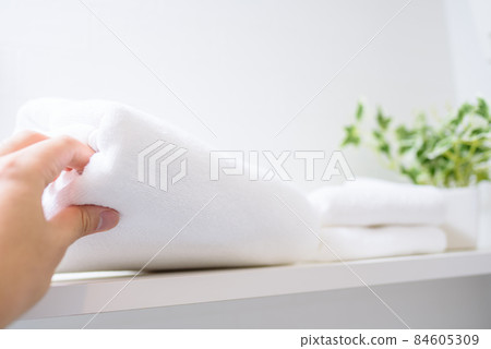 一個男人的手在架子上拿毛巾 一個男人的手在架子上拿毛巾 84605309