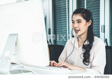 Businesswoman wearing headset working actively in office 84606080