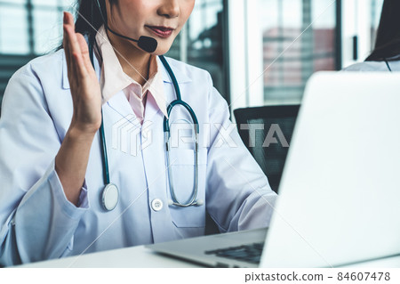 Doctor wearing headset talking actively on video call in hospital or clinic 84607478