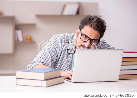 Young male student preparing for exams at home Young male student preparing for exams at home 84608030