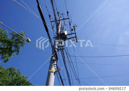 Utility poles and wires on a sunny day 84609217