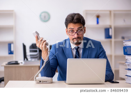 Young businessman employee unhappy with excessive work in the of Young businessman employee unhappy with excessive work in the of 84609439