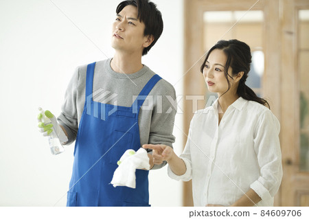 一個打掃衛生的男人和一個微笑著看著的孕婦 84609706