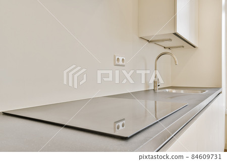 Stylish modern electric stove with sink in the background Stylish modern electric stove with sink in the background 84609731